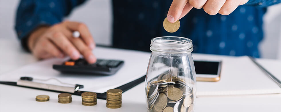 man saving coins in a jar